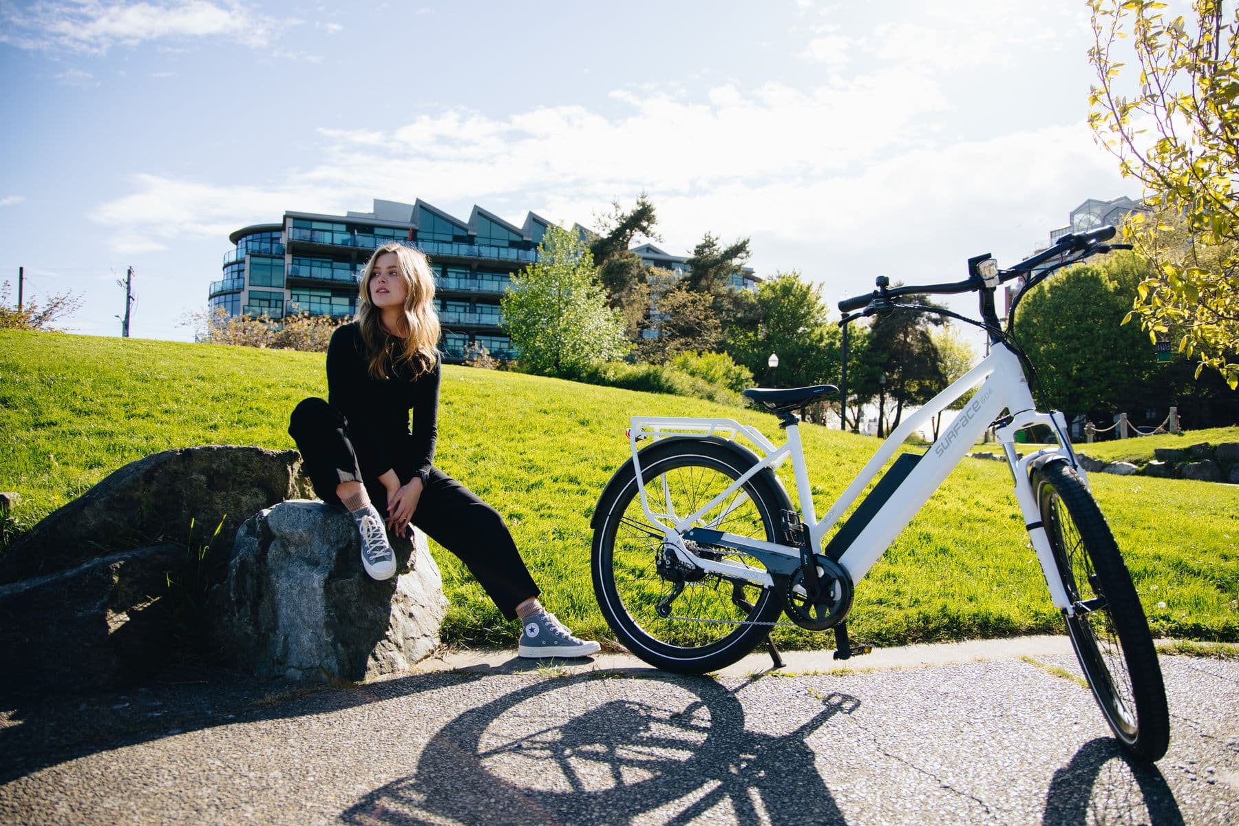 Rider resting beside a white Surface 604 Rook in a city park
